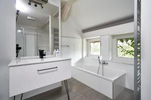 a white bathroom with a tub and a sink at Dobra Chata Jaśkowo in Wiartel
