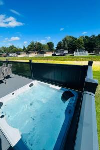 a jacuzzi tub on a roof with a field at Laburnum Lodge with Hot Tub in York