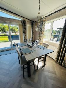 a dining room with a table and chairs and windows at Laburnum Lodge with Hot Tub in York