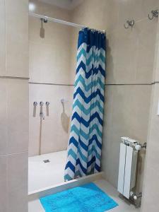 バレリア・デル・マールにあるArenas 1のバスルーム(青と白のシャワーカーテン付きのシャワー付)