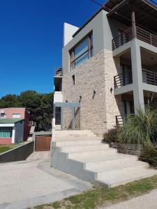 a brick building with stairs in front of it at Arenas 1 in Valeria del Mar