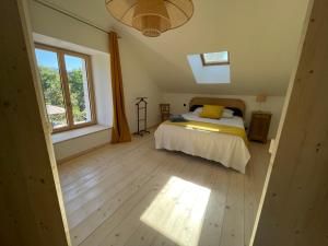 a bedroom with a bed and a large window at Maison près de la rivière in Arbois