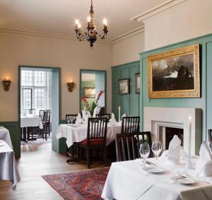a dining room with white tables and a fireplace at Ard na Sidhe Country House Hotel in Killorglin