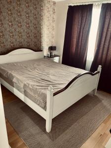 a white bed in a bedroom with a window at Nomad Reghin in Reghin