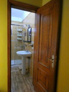 a bathroom with a sink and a wooden door at Casa Goliath in Isora