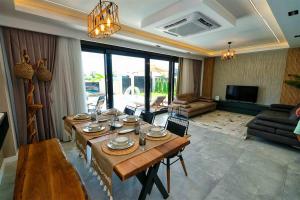 uma sala de estar com uma mesa e um sofá em Yedisu Villaları Family Only em Kemer