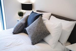 a pile of pillows on a bed in a bedroom at Modern 1-Bed Apartment - City Centre - FREE Wi-Fi - New - in Manchester