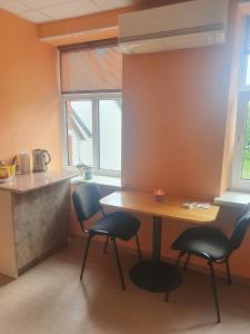 a kitchen with a table and two chairs and a counter at Ukstiņa ielas apartamenti in Liepāja