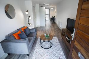a living room with a couch and a table at Modern 1-Bed Apartment - City Centre - FREE Wi-Fi - New - in Manchester