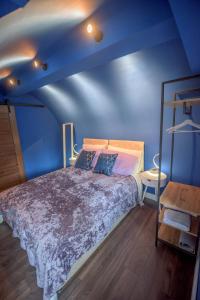 een blauwe slaapkamer met een bed en een blauwe muur bij Cosy Vaulted Flat with Terrace in Bath