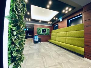 a lobby with a green wall in a building at Hotel Hulaton Fukuokahakata in Fukuoka