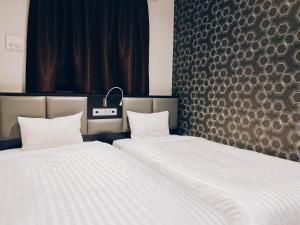 dos camas sentadas una al lado de la otra en una habitación en Hotel Hulaton Fukuokahakata, en Fukuoka