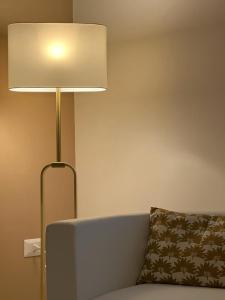 una lámpara junto a un sofá con almohada en TIZIANA'S HOUSE en Salerno