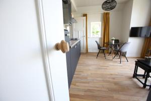 een keuken en eetkamer met een houten vloer bij Recreatieappartement BoerdeRijlst - De Winkel in Sint Nicolaasga