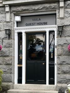 uma frente de uma casa de hóspedes com uma porta preta em Vaila Guest House em Aberdeen