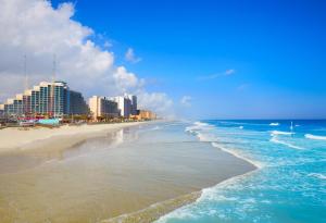 een uitzicht op het strand met gebouwen en de oceaan bij Daytona Beach Resort - Ocean Front Luxury Studio in Daytona Beach