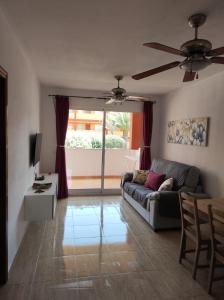 a living room with a couch and a ceiling fan at Casa Guira - Fuerteventura in Parque Holandes