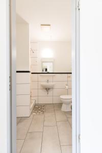 a bathroom with a toilet and a sink at GROBO Apartments in Hamburg