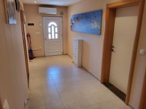 un couloir avec une porte blanche et du carrelage. dans l'établissement Apartment Leonardo, à Vrsi