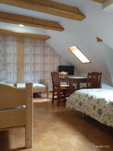 a room with a bed and a table and chairs at Kazkowa Koliba in Zakopane