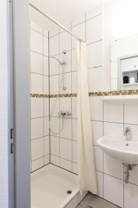 bagno con doccia e lavandino di GROBO Apartments ad Amburgo