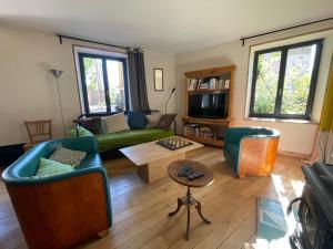 a living room with a couch and a table at Maison près de la rivière in Arbois