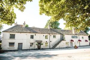 Un grand bâtiment blanc avec des escaliers y mène. dans l'établissement Trouble House, à Tetbury