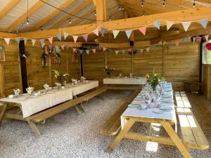 a dining room with tables in a wooden building at Trouble House in Tetbury