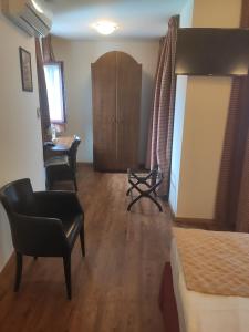 een slaapkamer met een bed, een stoel en een bureau bij Hotel Van Reeth's Koffiebranderij in Puurs