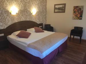 een slaapkamer met een bed met 2 kussens erop bij Hotel Van Reeth's Koffiebranderij in Puurs
