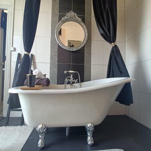 La salle de bains est pourvue d'une baignoire blanche et d'un miroir. dans l'établissement Entre Bastide et Cité, à Carcassonne