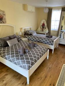 two beds in a bedroom with wooden floors at The Ashton Mews in Bristol