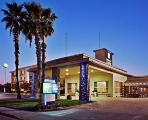 a hotel with palm trees in front of a building at Holiday Inn Express Corning by IHG in Corning