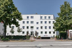 een wit gebouw aan de straatkant bij GROBO Apartments in Hamburg