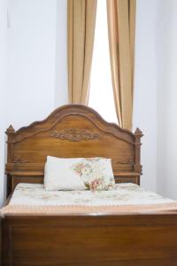 a bed with a wooden head board with a pillow at Vila murah di dekat kawasan wisata lembang in Citeureup 1