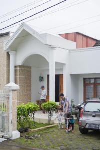 une famille debout devant une maison dans l'établissement Vila murah di dekat kawasan wisata lembang, à Citeureup 1
