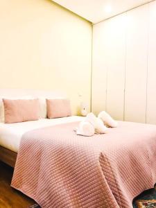 um quarto com uma cama grande com lençóis e almofadas cor-de-rosa em Almeida's House em Viana do Castelo