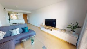 uma sala de estar com um sofá azul e uma televisão de ecrã plano em Casa Cocotero C-A Murcia Holiday Rentals Property em Torre-Pacheco