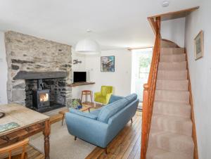 a living room with a staircase and a fireplace at Ty Bach - Llanberis in Caernarfon