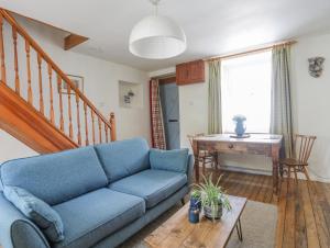 a living room with a blue couch and a table at Ty Bach - Llanberis in Caernarfon