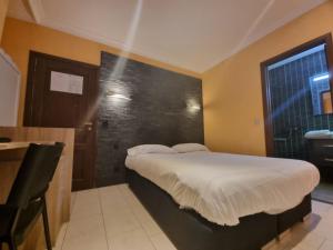 een slaapkamer met een bed met een zwarte muur bij Avalon Hotel in Overijse