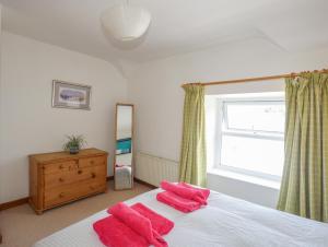 a bedroom with a bed with red towels on it at Ty Bach - Llanberis in Caernarfon