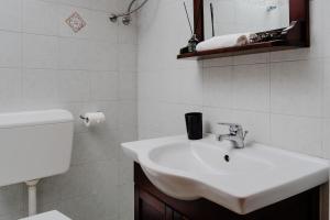 ナクソス・コラにあるSmall Apartment in Grotta Naxosの白いバスルーム(洗面台、トイレ付)
