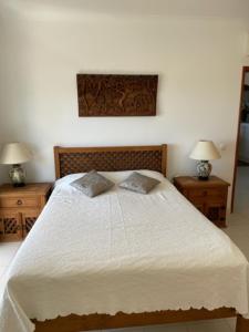 a bedroom with a large white bed with two night stands at Appartement Praia da Luz - 2 Personnes - Vue mer in Luz