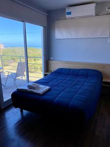 - une chambre avec un lit bleu et un balcon dans l'établissement Container Cubo Hotel, à Quequén
