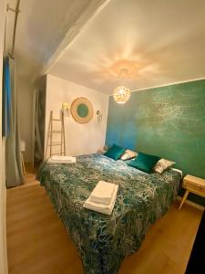 1 dormitorio con 1 cama con pared verde en Rue Marceau Cogolin, en Cogolin