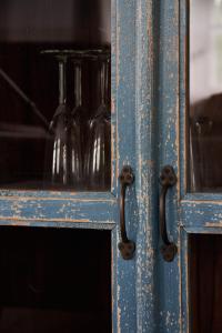 an old blue cabinet with a glass bottle in it at Dobra Chata Jaśkowo in Wiartel