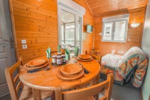 comedor de madera con mesa y sillas en Village de Gîtes des Chalets du Camping du Golf, en La Canourgue