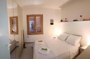 a bedroom with a white bed and two windows at Casa Faedda Costa Paradiso in Costa Paradiso