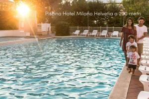 a family standing in front of a swimming pool at La Mansardina in Riccione